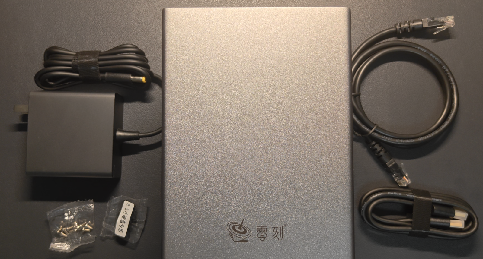 开箱全家福：主机本体、120W 电源适配器、6 类网线、HDMI 线与两包螺丝